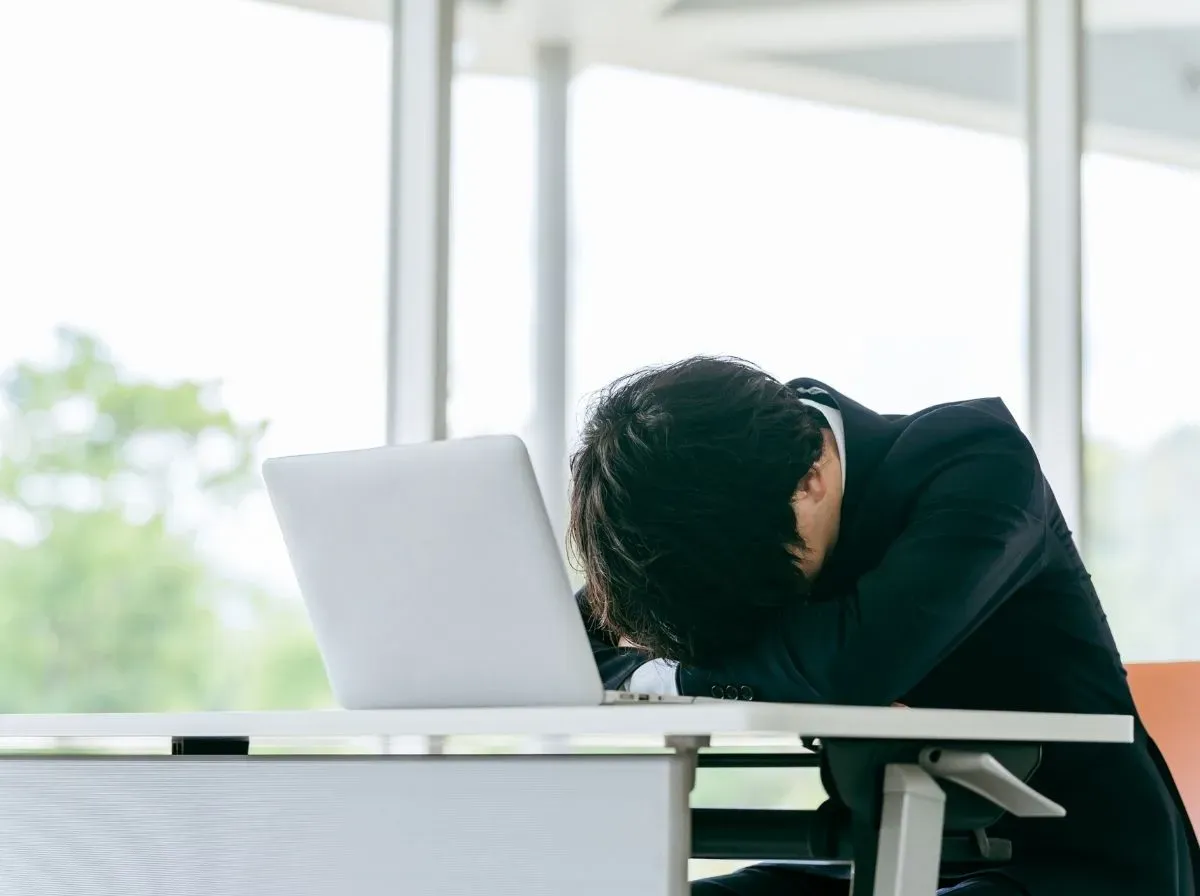 パソコンの前で寝る人