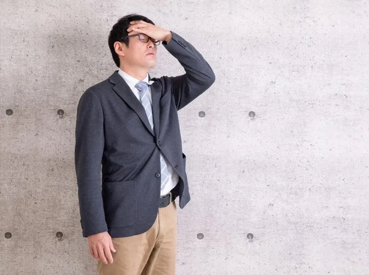 頭を抑える男性