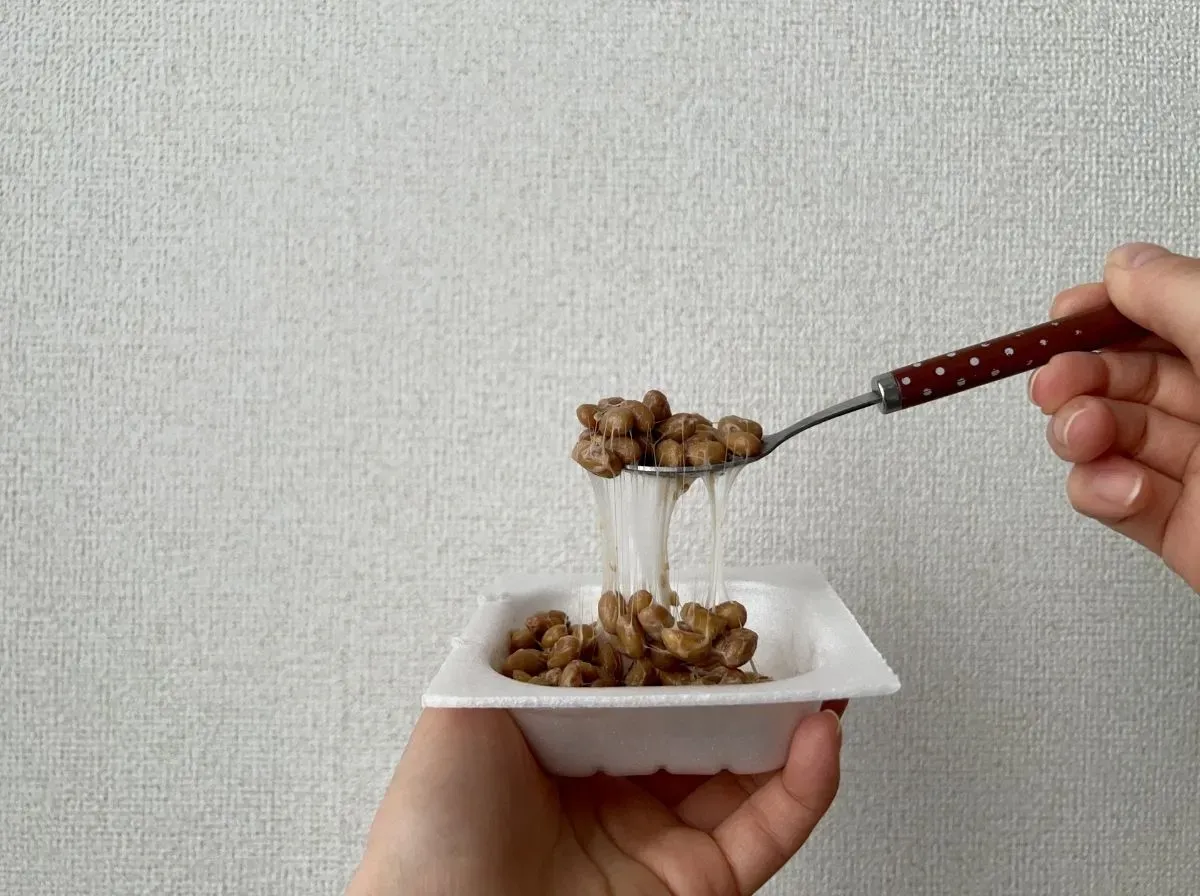 納豆をスプーンで持ち上げる人
